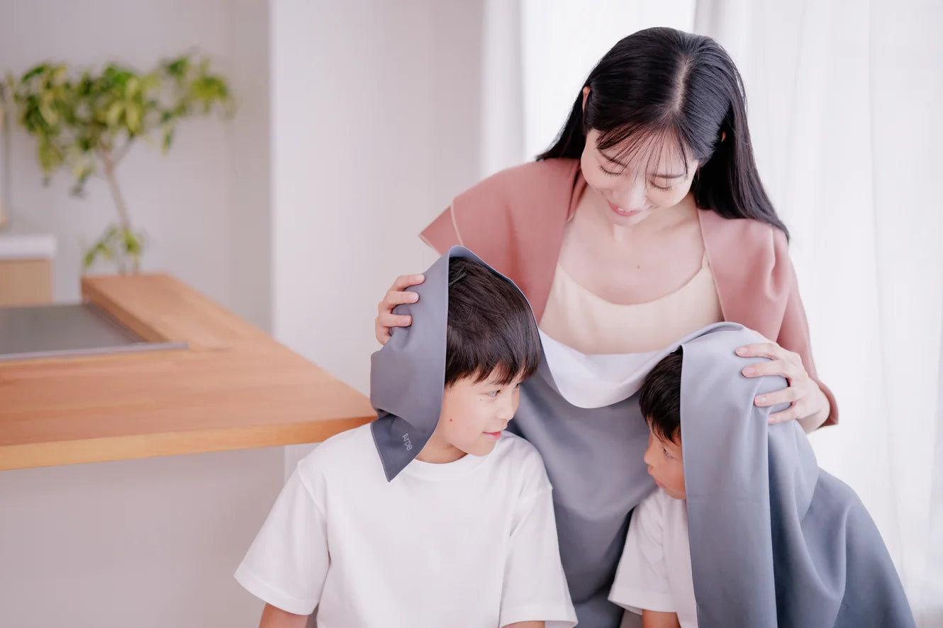 Arpeタオルで子どもの髪を拭く母親